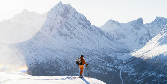 Ski touring guide 2025 - backcountry skier ascending snowy mountain slope with touring gear