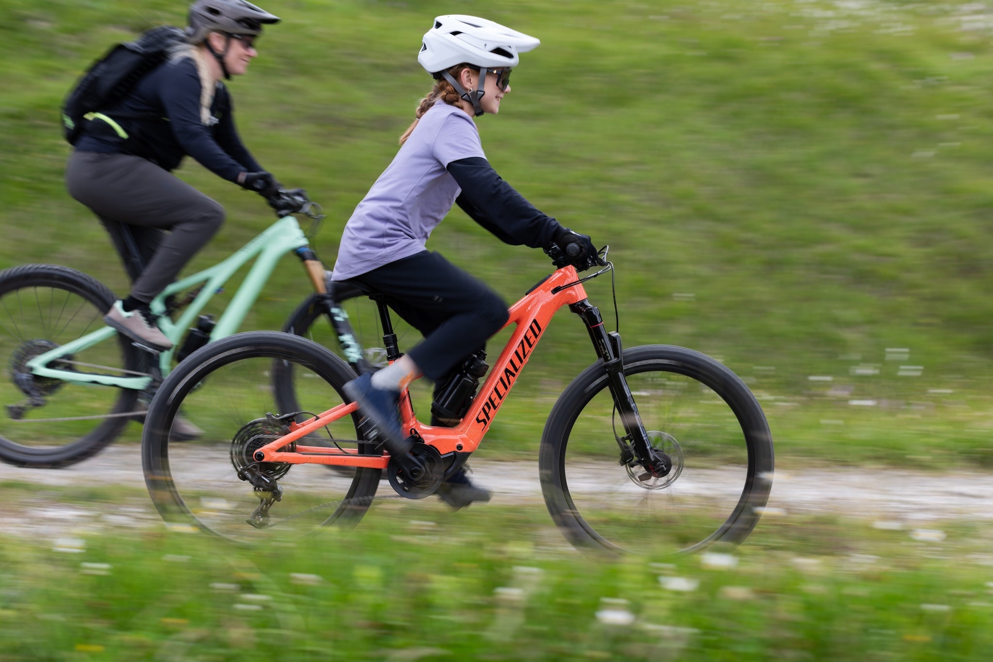Two people riding bicycles on a trail with blurred motion